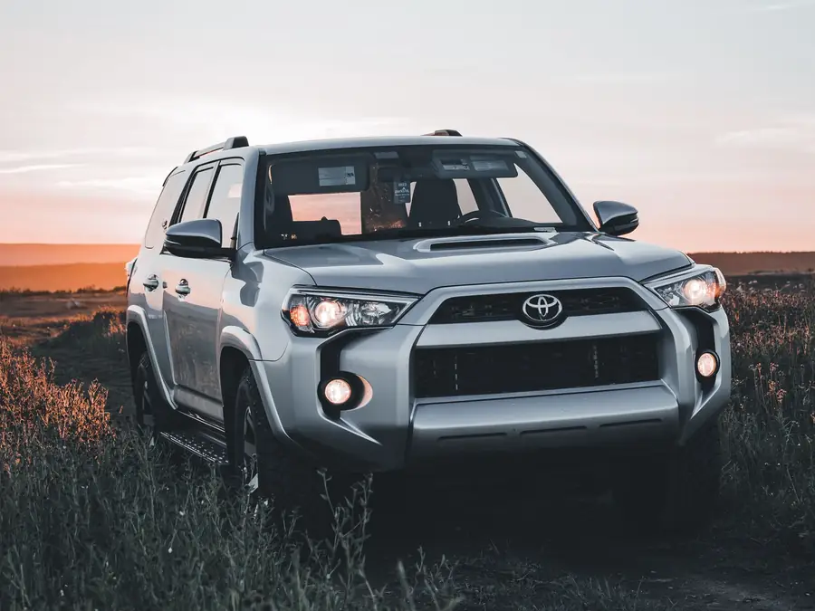 Silver Toyota 4Runner TRD Off-Road standing in open grassland at sunset