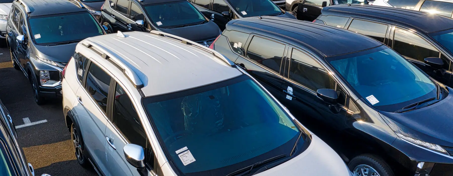 Rows of used cars waiting on the JE Auto lot